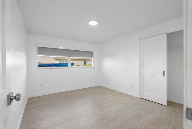 1984 Kansas Ave NE, Saint Petersburg, FL 33703 - unfurnished bedroom with light wood-style floors, baseboards, and a closet