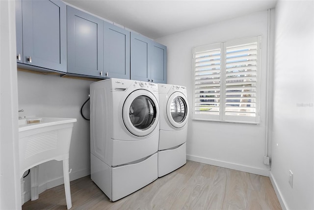 1984 Kansas Ave NE, Saint Petersburg, FL 33703 - laundry room with light wood-style floors, cabinet space, independent washer and dryer, and baseboards