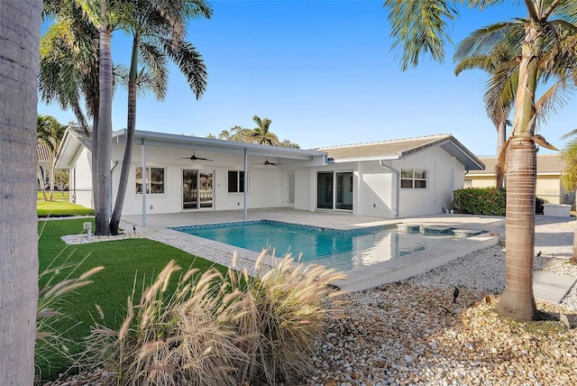 1984 Kansas Ave NE, Saint Petersburg, FL 33703 - back of property with a yard, a patio, stucco siding, a ceiling fan, and an outdoor pool
