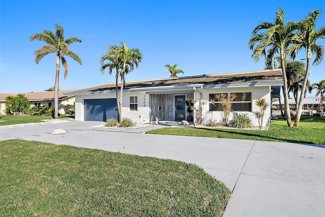 1984 Kansas Ave NE, Saint Petersburg, FL 33703 - view of front of property featuring an attached garage, a front lawn, concrete driveway, and stucco siding