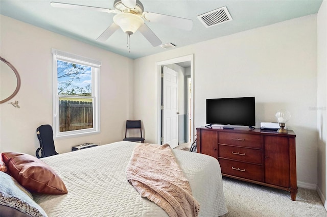 bedroom with light carpet, ceiling fan, visible vents, and baseboards