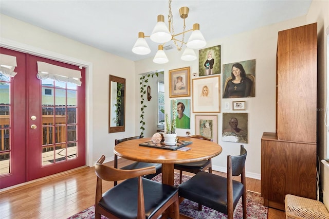 dining room featuring french doors, baseboards, an inviting chandelier, and wood finished floors