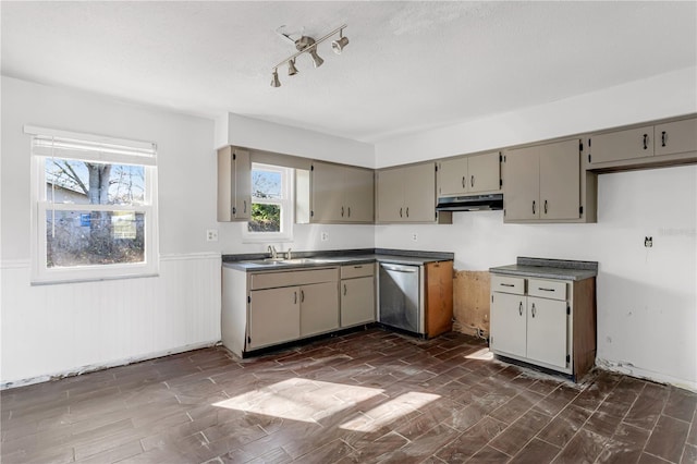 kitchen featuring wainscoting, dishwasher, under cabinet range hood, and gray cabinetry