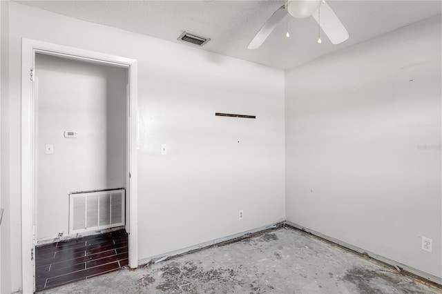 spare room featuring ceiling fan, visible vents, and unfinished concrete floors