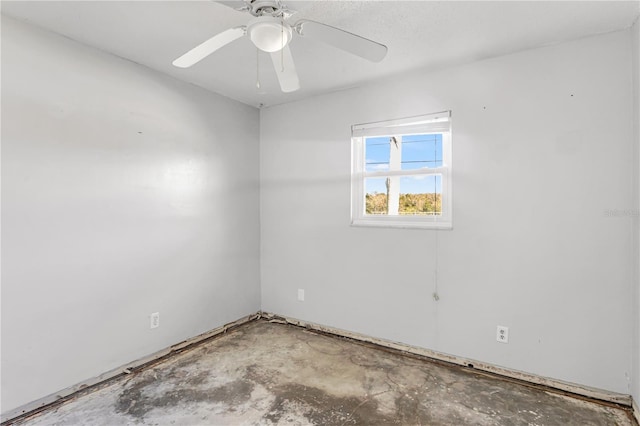 spare room with ceiling fan and concrete floors