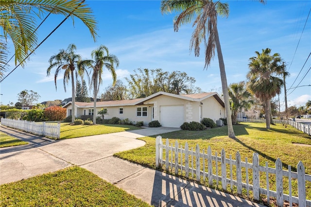 view of front of house with a fenced front yard, a garage, concrete driveway, stucco siding, and a front yard