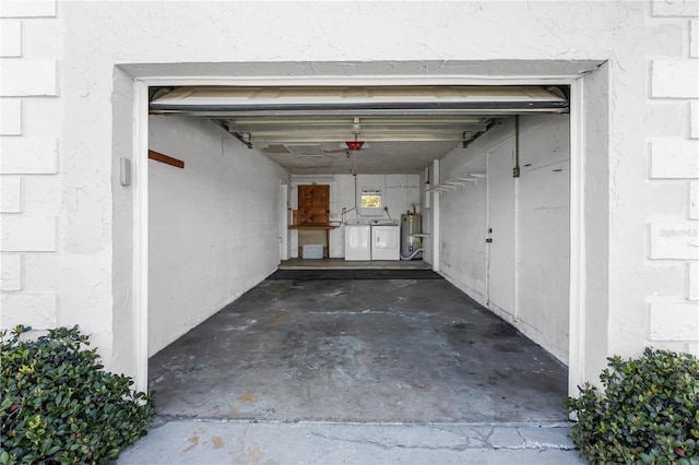 garage with washer and clothes dryer and gas water heater