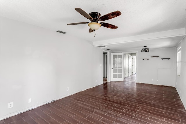 empty room featuring a ceiling fan, visible vents, a textured ceiling, and wood finished floors