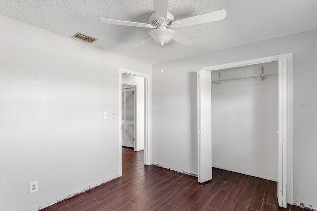 unfurnished bedroom with a textured ceiling, wood finished floors, visible vents, a ceiling fan, and a closet