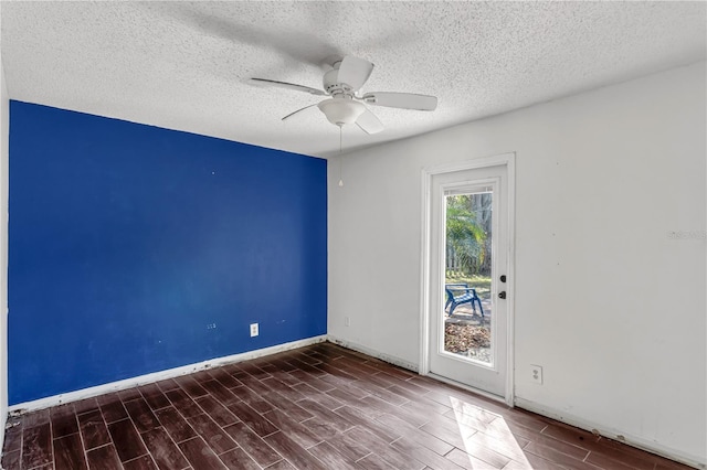 spare room featuring wood tiled floor, a textured ceiling, baseboards, and a ceiling fan