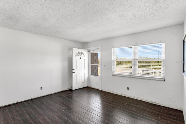 empty room featuring dark wood-type flooring and a textured ceiling