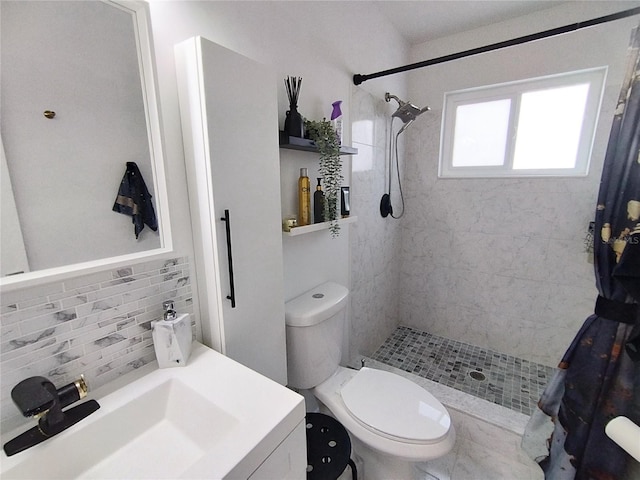 bathroom with toilet, a tile shower, decorative backsplash, and a sink