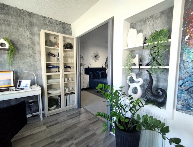 interior space featuring a textured ceiling and wood finished floors