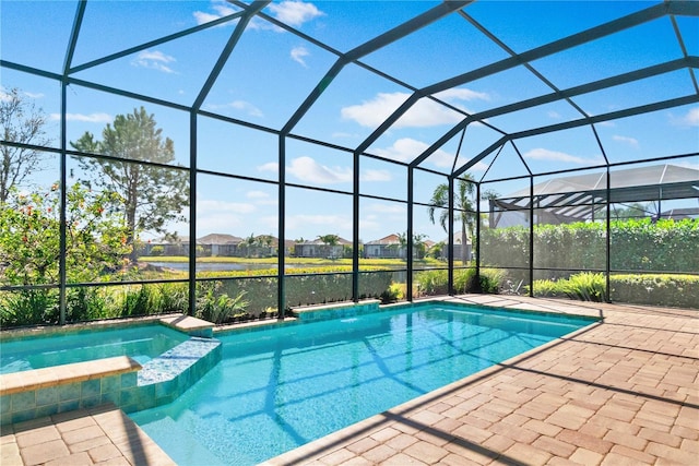 view of swimming pool featuring a pool with connected hot tub, glass enclosure, and a patio