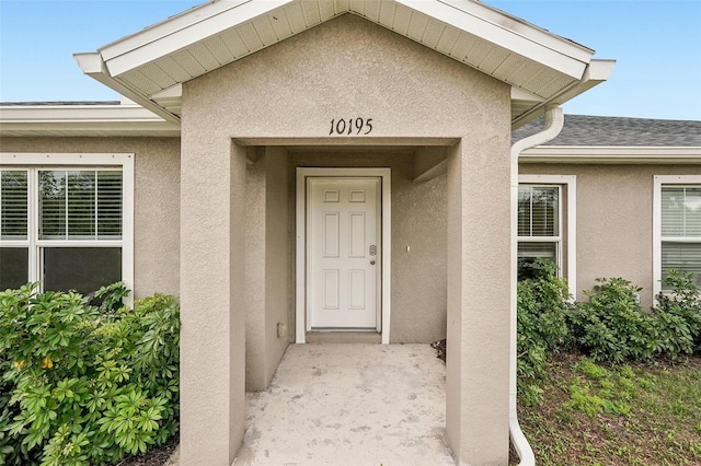 property entrance with stucco siding