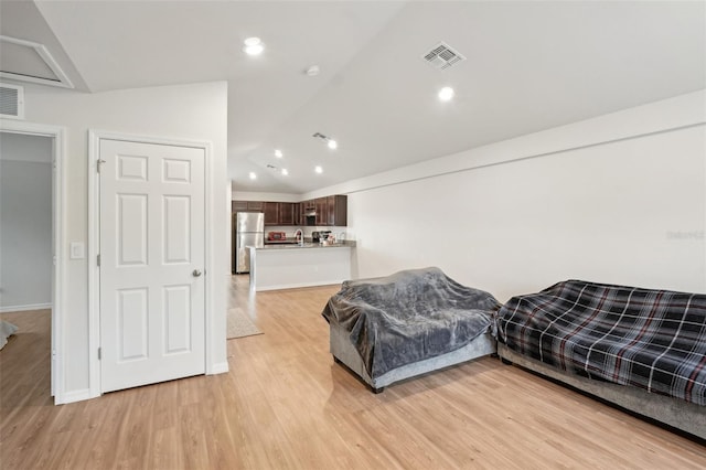 living room with vaulted ceiling, recessed lighting, visible vents, and light wood-style floors