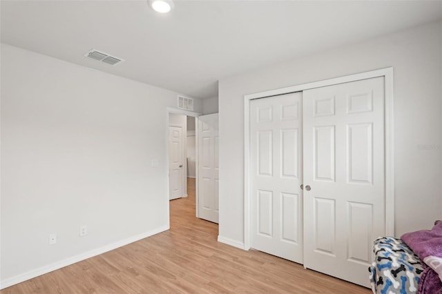 unfurnished bedroom with light wood-style flooring, visible vents, and baseboards