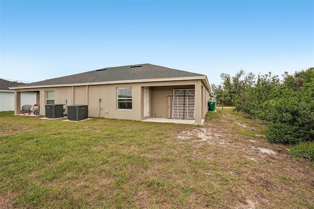 rear view of property with a patio, a lawn, cooling unit, and stucco siding