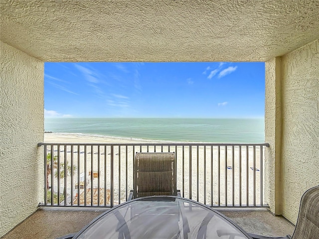 balcony featuring a water view and a view of the beach