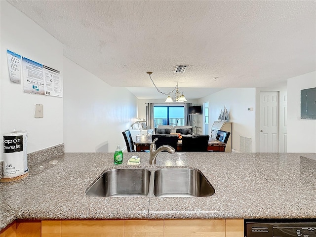 kitchen featuring a textured ceiling, electric panel, open floor plan, and a sink