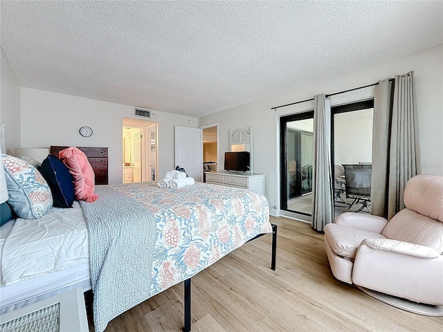 bedroom featuring a textured ceiling, light wood-type flooring, visible vents, and access to exterior