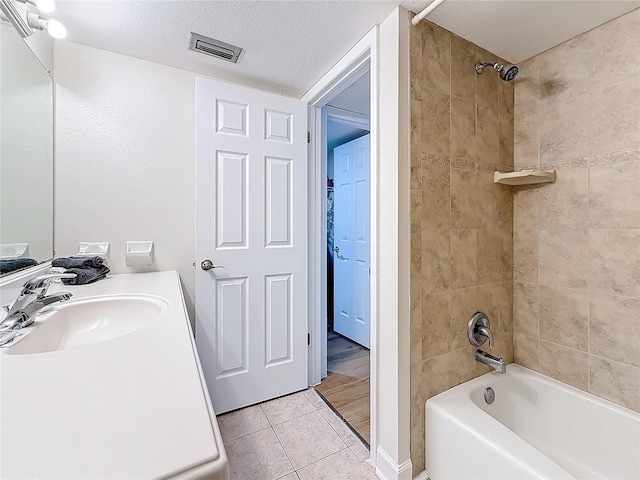 full bath with visible vents,  shower combination, tile patterned flooring, a textured ceiling, and vanity