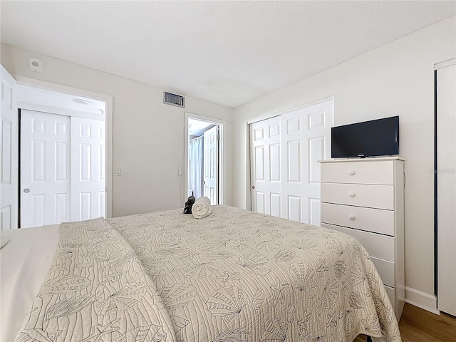 bedroom featuring visible vents and wood finished floors