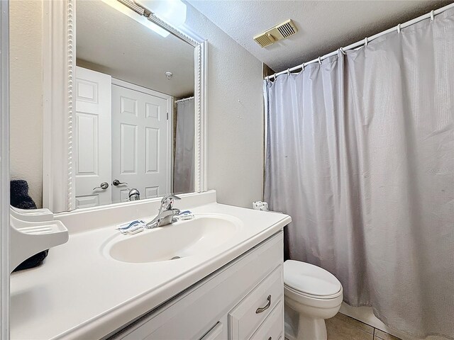 bathroom with visible vents, vanity, toilet, and tile patterned floors