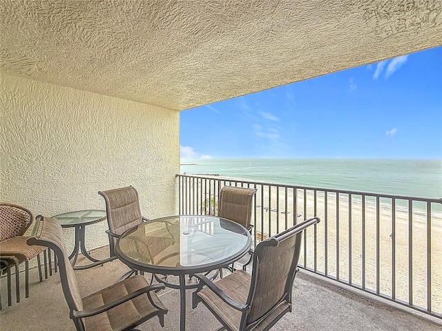 balcony featuring a water view and a beach view