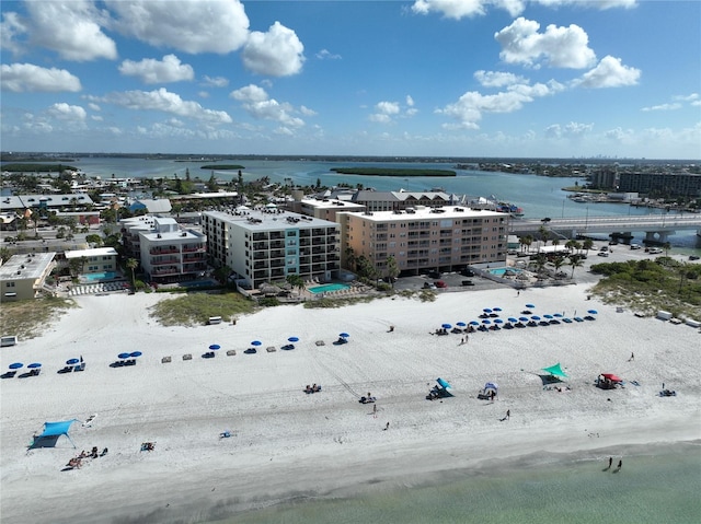 drone / aerial view featuring a water view, a view of city, and a beach view