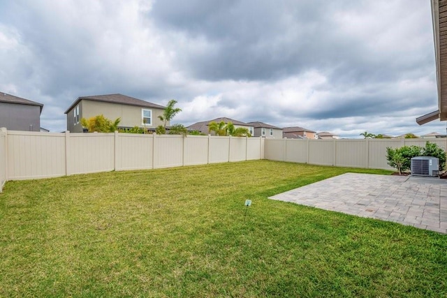 view of yard featuring a patio area, a fenced backyard, and central AC