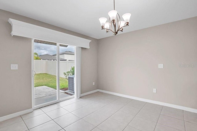 spare room featuring light tile patterned flooring, baseboards, and an inviting chandelier