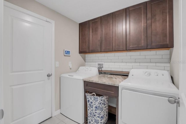 laundry room with cabinet space, washing machine and clothes dryer, and light tile patterned floors