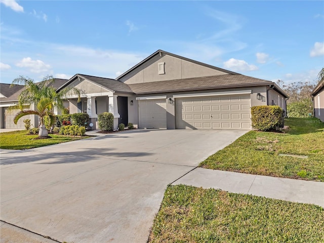 single story home with a front lawn, concrete driveway, an attached garage, and stucco siding