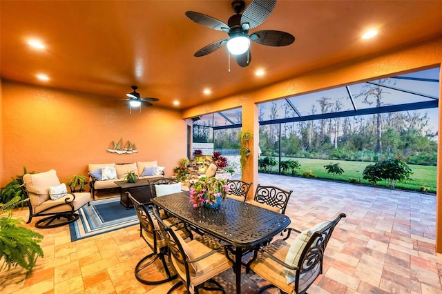 view of patio featuring a ceiling fan, outdoor dining area, glass enclosure, and an outdoor living space