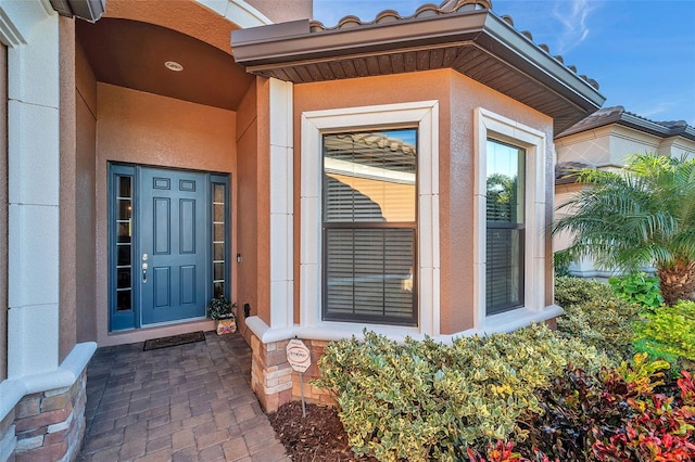 entrance to property featuring stucco siding