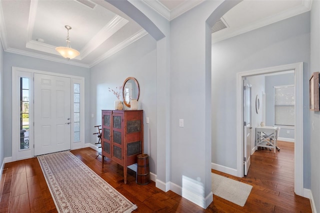 entryway featuring arched walkways, dark wood-style flooring, a tray ceiling, crown molding, and baseboards