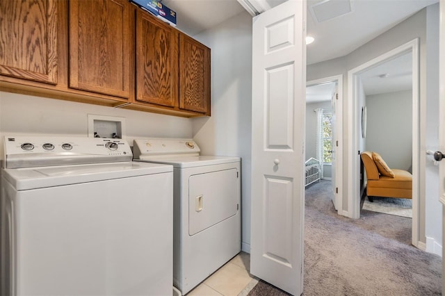 clothes washing area featuring washer and clothes dryer, light colored carpet, cabinet space, visible vents, and baseboards