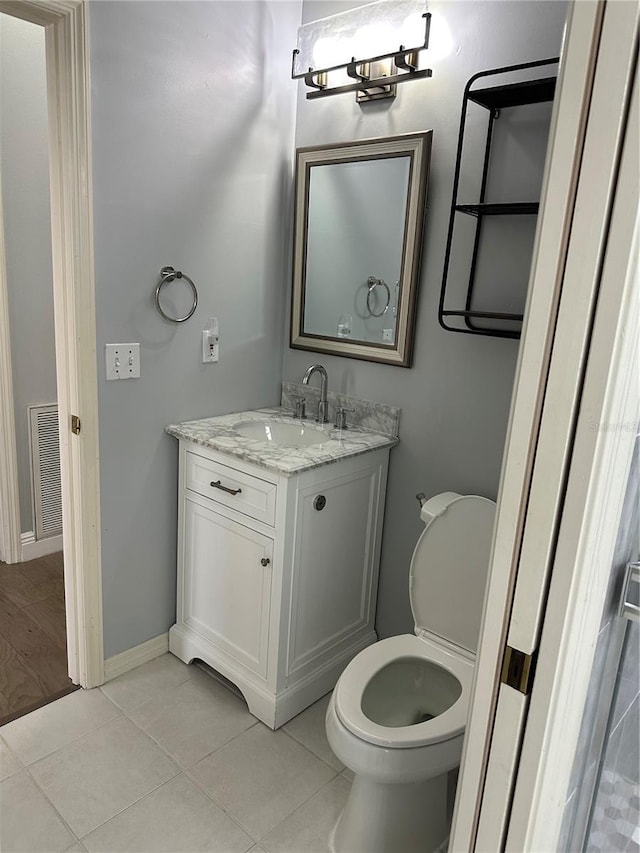bathroom with visible vents, baseboards, toilet, vanity, and tile patterned flooring