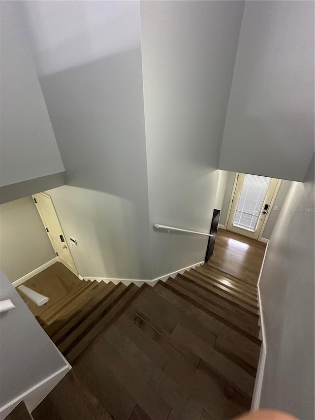 stairway featuring wood finished floors and baseboards