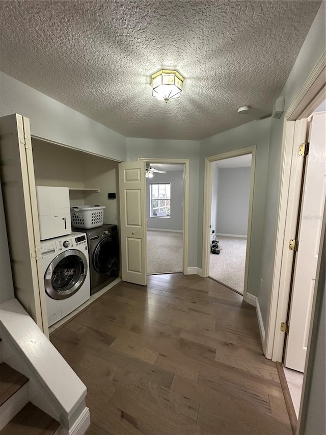 laundry area featuring dark wood-style flooring, baseboards, laundry area, and a textured ceiling