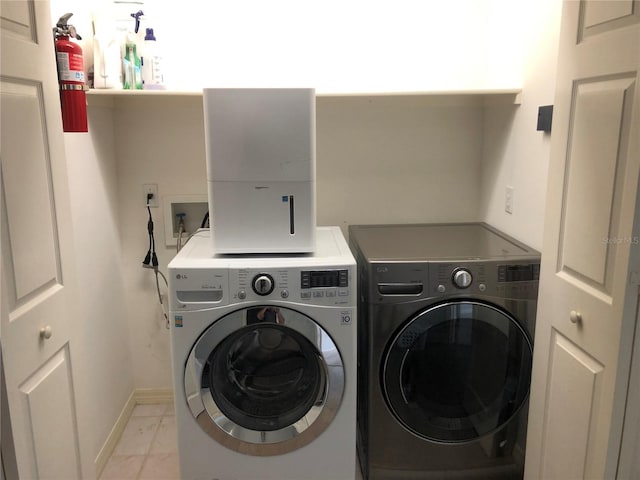 laundry area with marble finish floor, washer and clothes dryer, baseboards, and laundry area