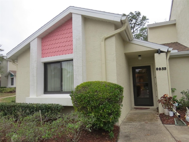 entrance to property featuring stucco siding