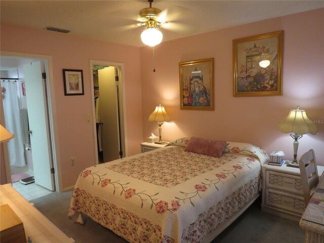 bedroom with visible vents, a closet, a walk in closet, carpet, and ensuite bath