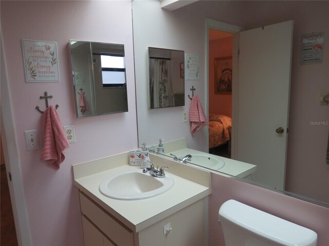 bathroom with toilet, ensuite bath, and vanity