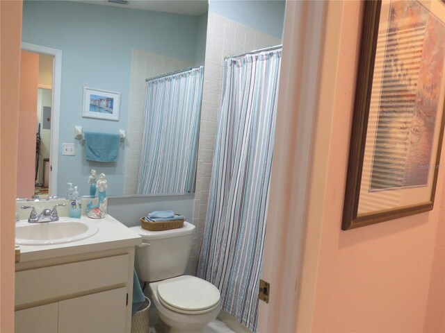 full bath featuring toilet, curtained shower, and vanity