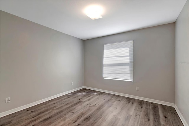 empty room with light wood-style floors and baseboards