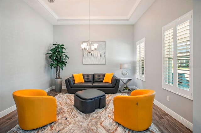 living room featuring a tray ceiling, baseboards, and wood tiled floor