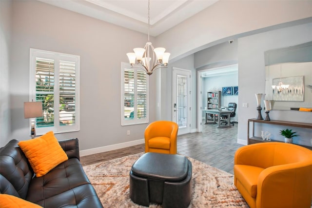 living area with an inviting chandelier, wood finished floors, and baseboards