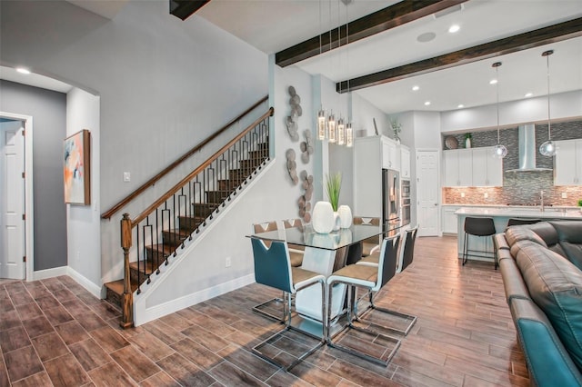 dining room featuring wood finished floors, baseboards, recessed lighting, stairs, and beamed ceiling